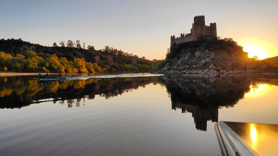 Almourol Castle mirrored in the still water of the Tagus at dusk.